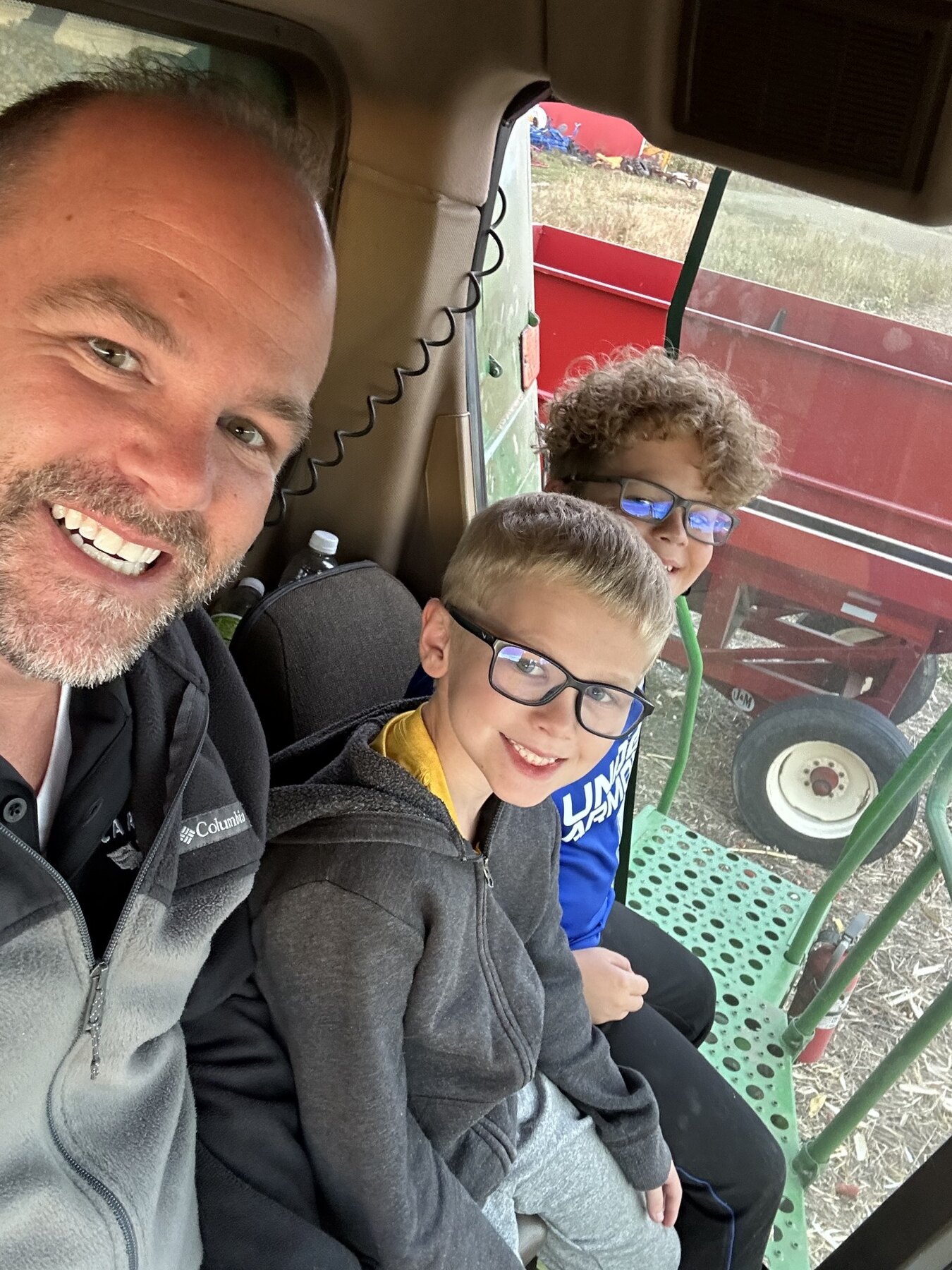 Carlton Randall with his sons inside a combine